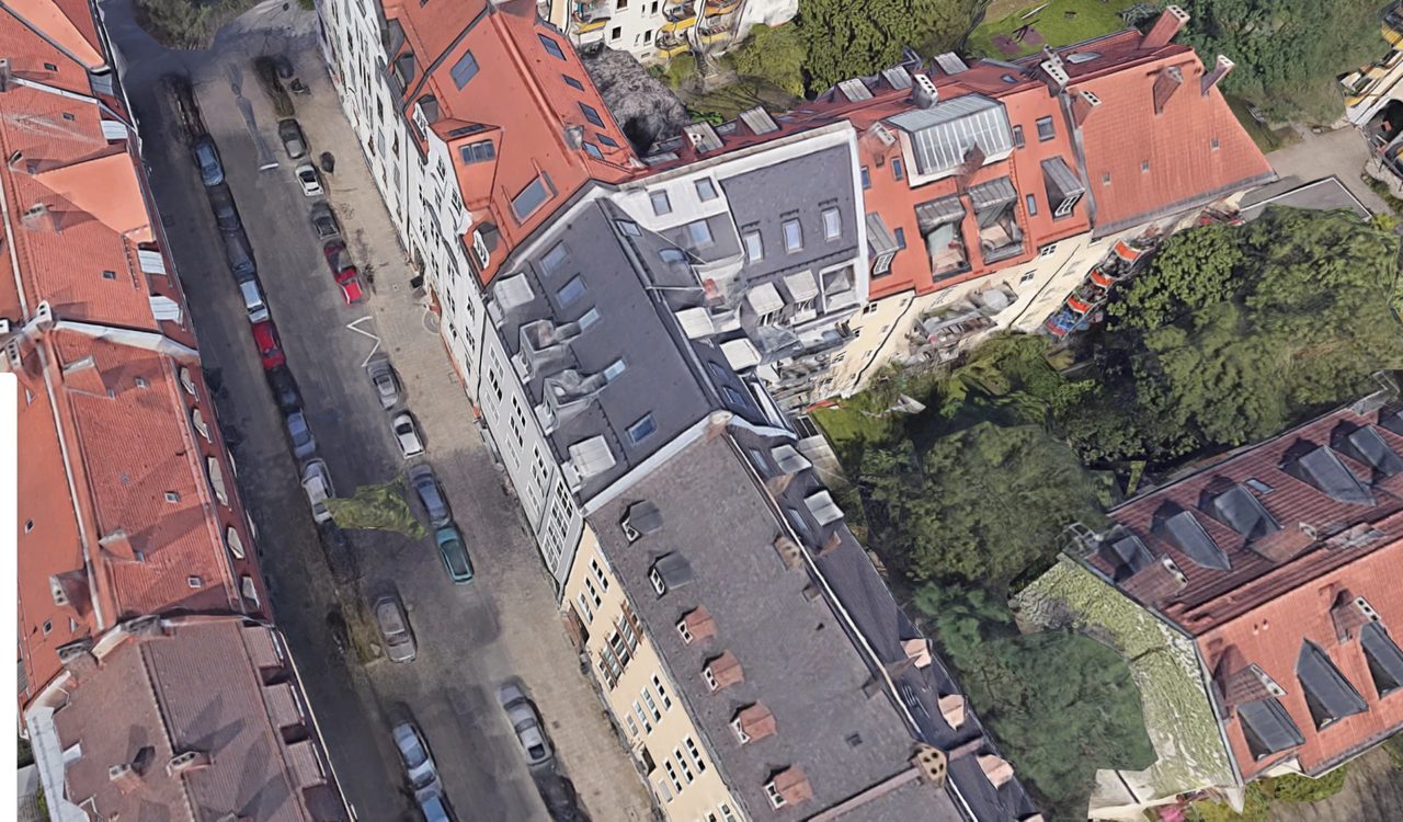 Luftaufnahme eines Münchner Blockrands mit begrüntem Innenhof und Dachbaustelle